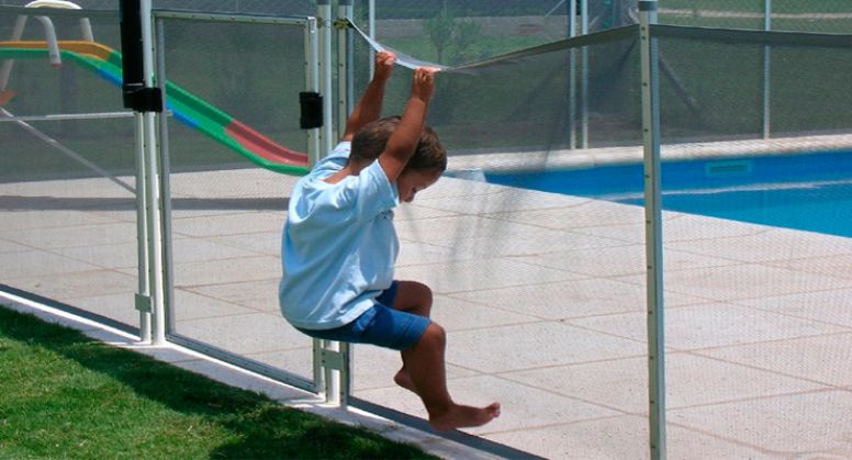 Niño intentando trepar en una valla de seguridad para piscinas de Babysecur